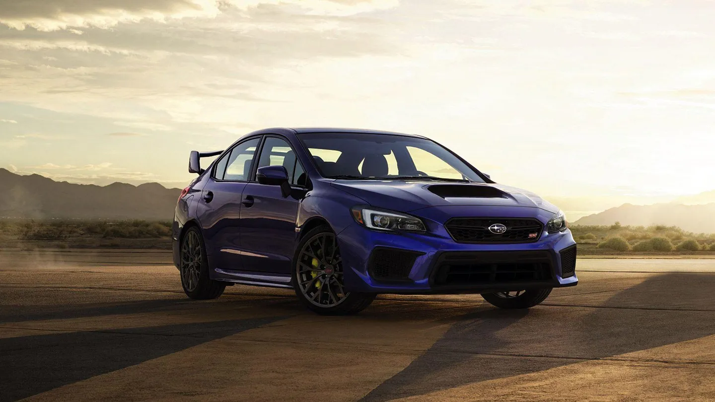 A blue Subaru performance car at sunset
