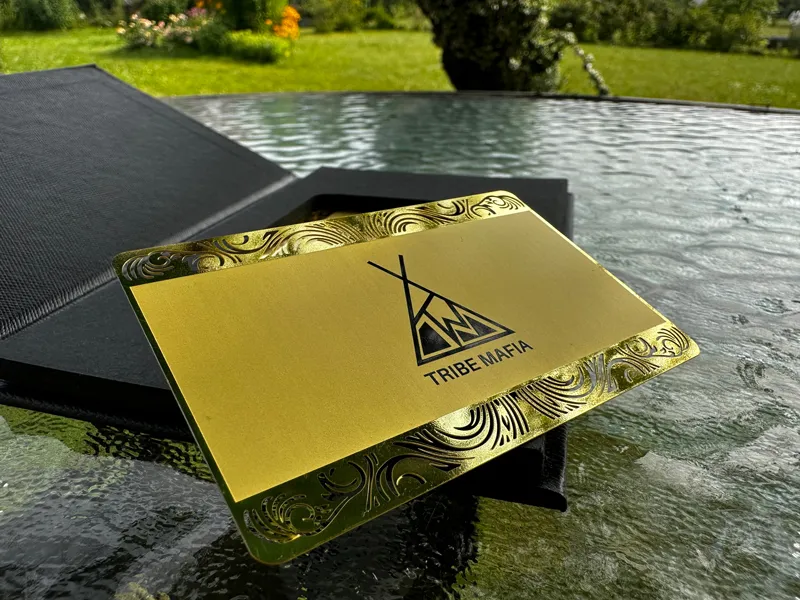 A gold-coloured metal card on its presentation box