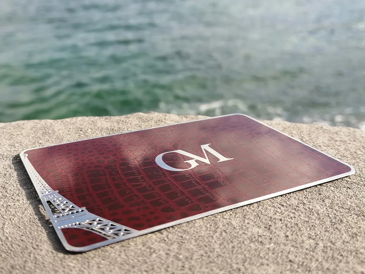 A GM metal membership card beside water