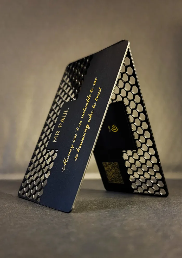 Two patterned metal business cards standing upright