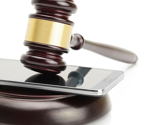 A judge's gavel above a tablet