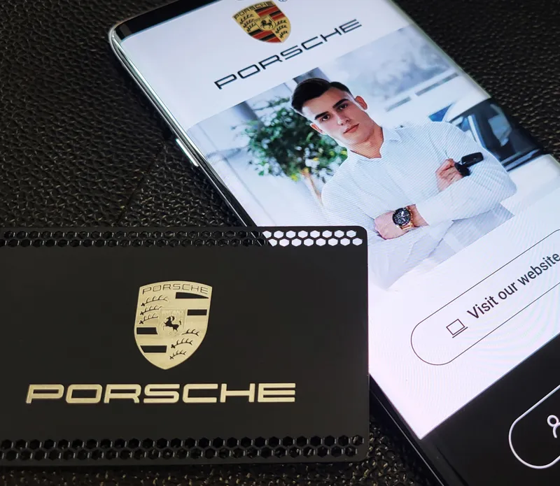 A Porsche-branded metal card beside a digital profile on a phone