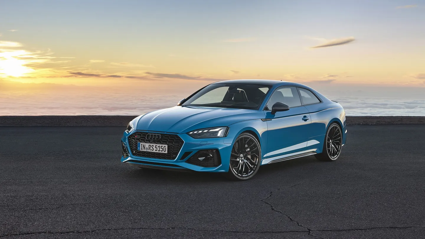 A blue Audi RS5 coupe beside the coast