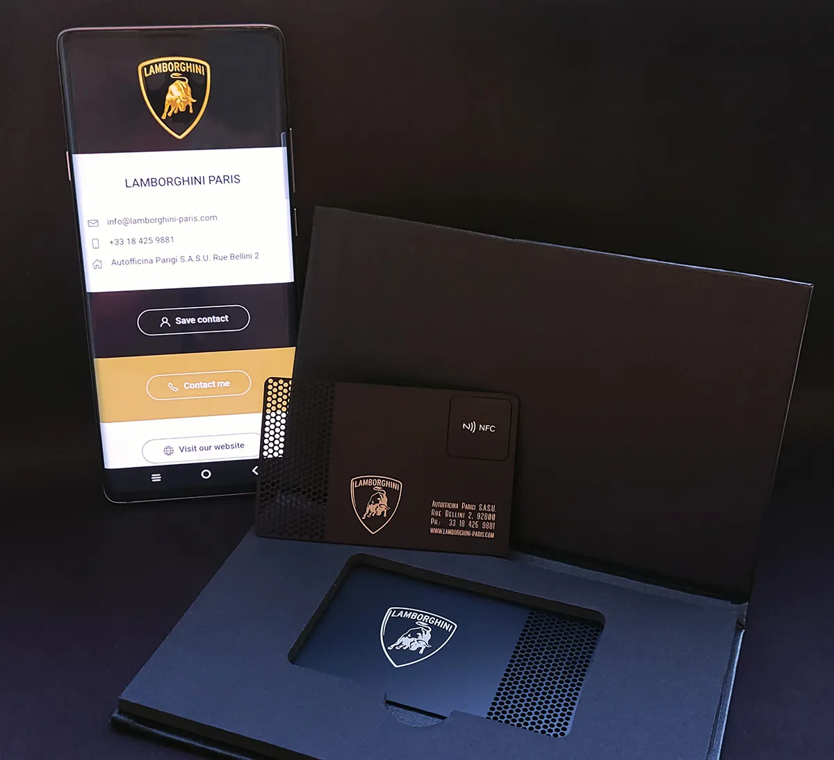 A Lamborghini-branded metal card beside its digital profile on a phone
