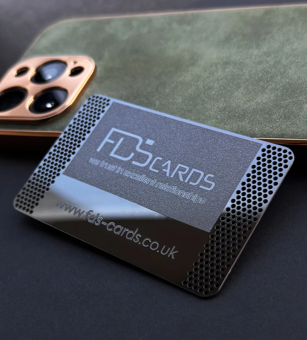 An engraved FDS Cards metal card beside a phone