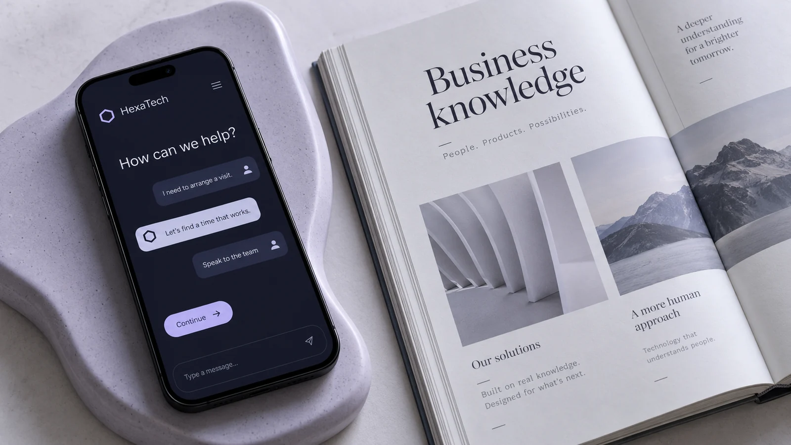 HexaTech AI conversation on a phone beside a business knowledge book